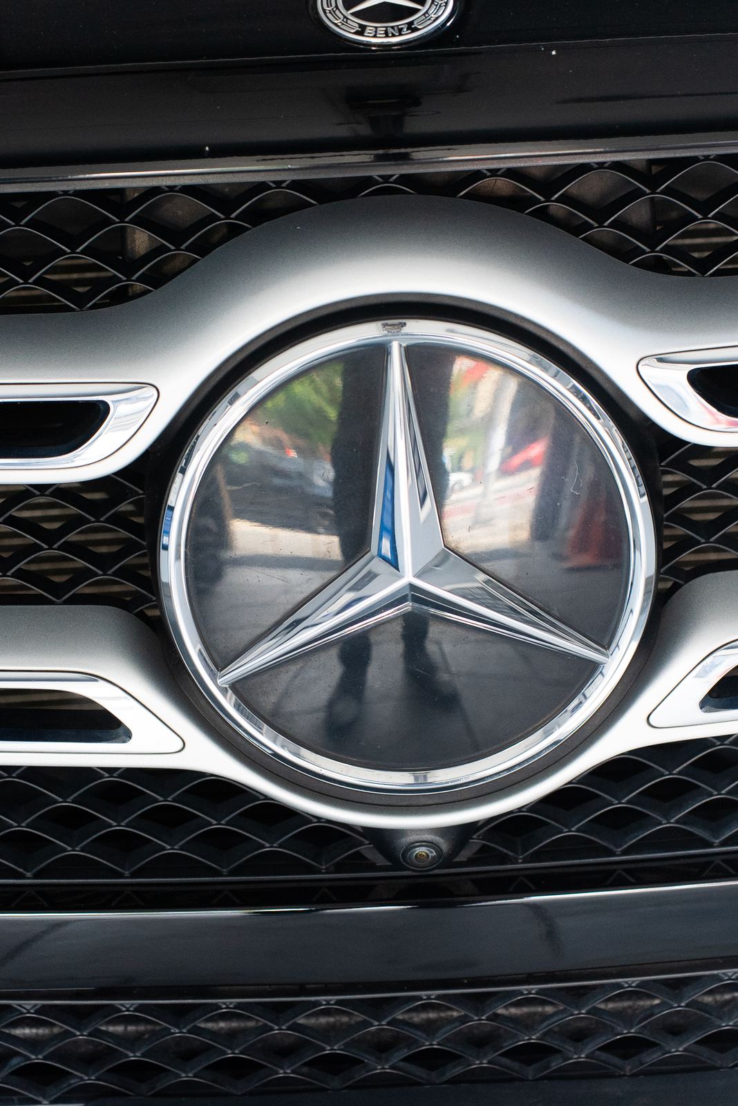 Close-up of a Mercedes-Benz grille badge at an NYC auto repair shop