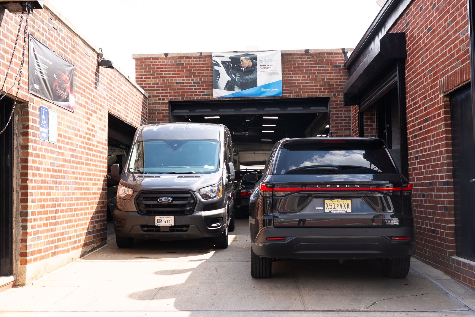 Exterior of a certified collision repair shop in NYC with vehicles parked outside