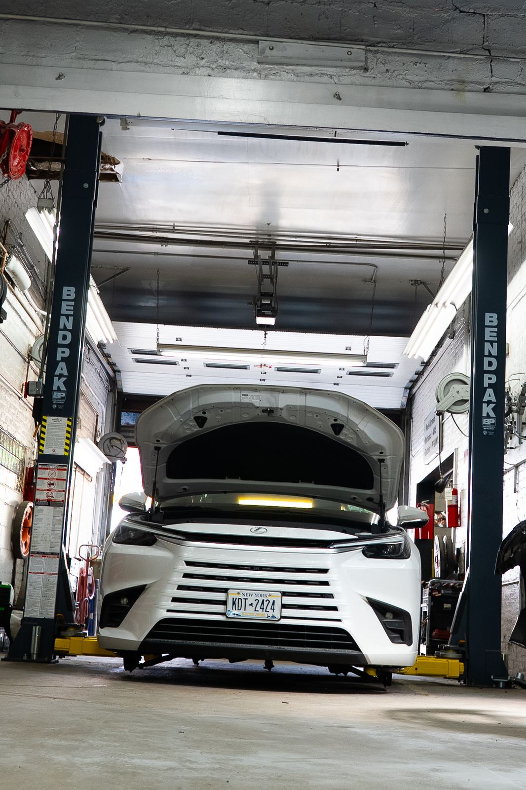 Vehicle raised on a lift for repair at an NYC auto shop, shot for a Getalife Studios client
